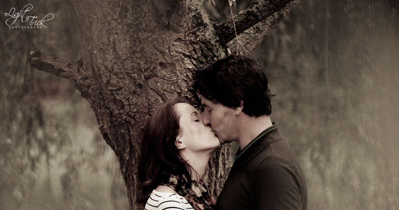 couple kissing under a weeping willow tree
