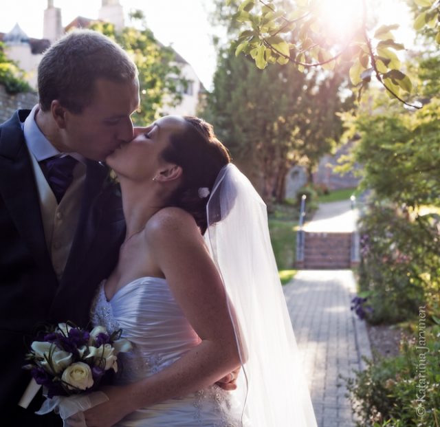 wedding couple kiss backlit into sun