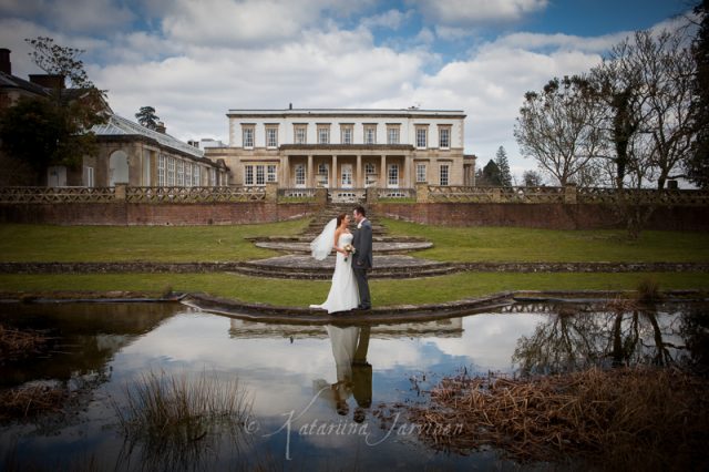 wedding couple posing in front of the pond at Buxted Park hotel, East Sussex