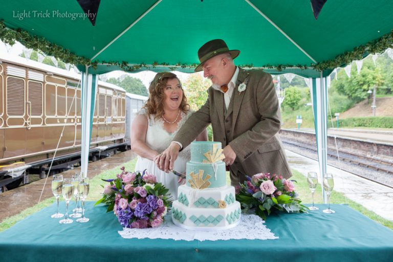 cutting wedding cake on platform Horstead Keynes wedding